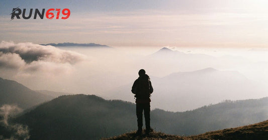 Benefits of Flat Insoles: Hike looking at the horizon on top of a mountain.